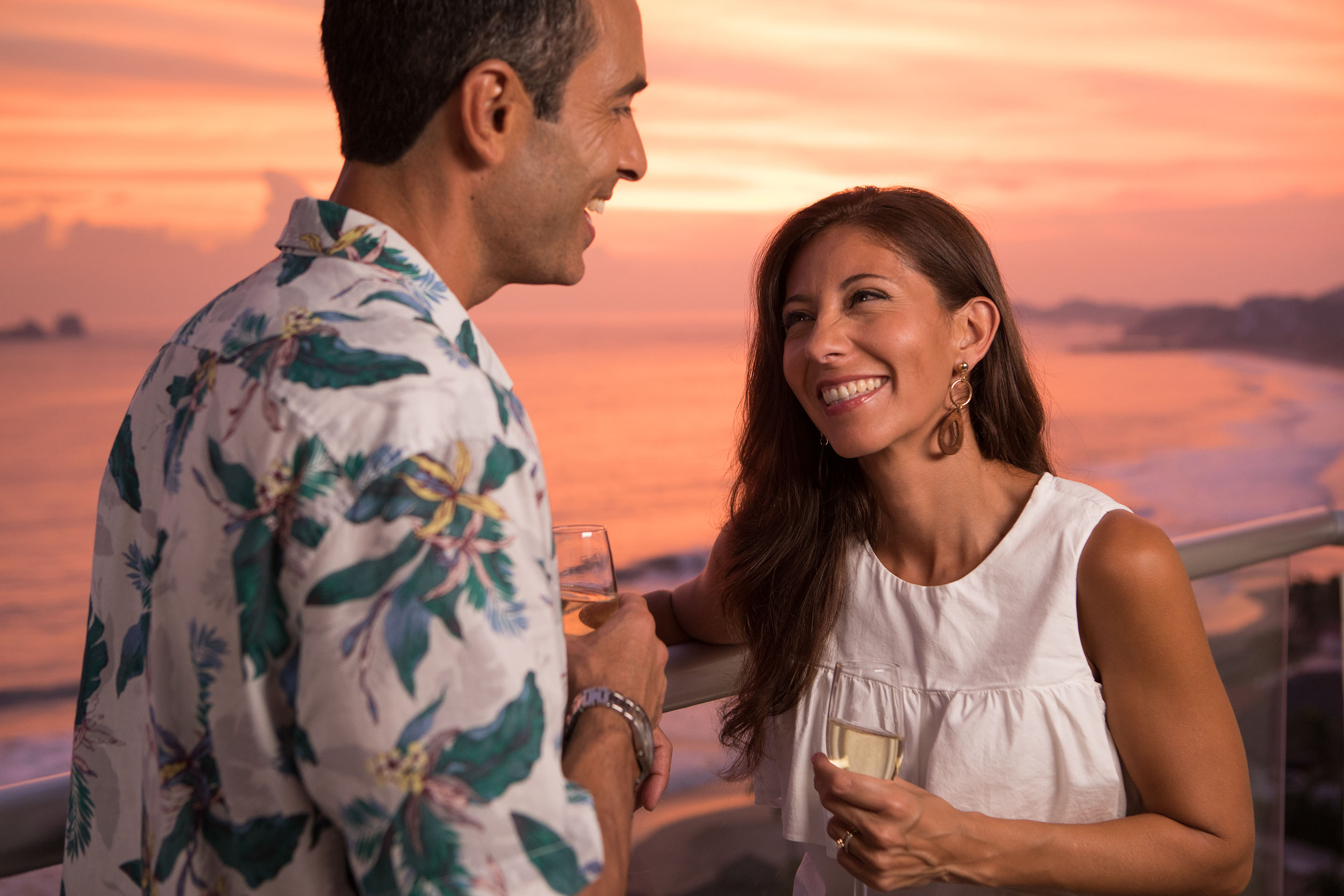 Husband and wife drinking champagne and laughing on the terrace